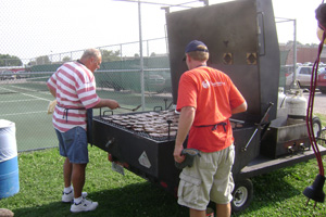 Photo of two men grilling on a huge gas grill