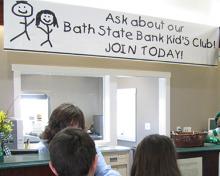 banner promoting kids club in bank lobby