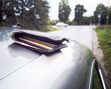 forgotten wallet on top of car driving on road